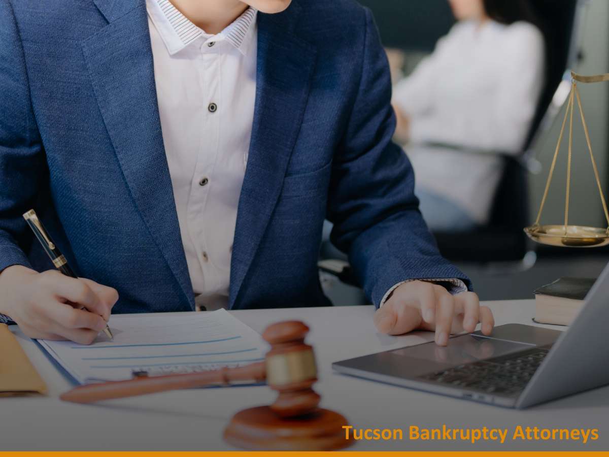 Attorney reviewing documents and using a laptop while handling a bankruptcy case